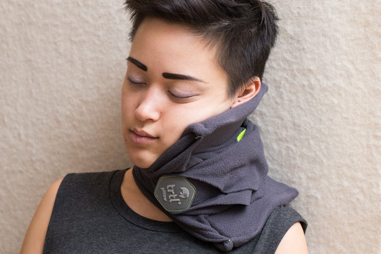 Woman wearing the Trtl Pillow.